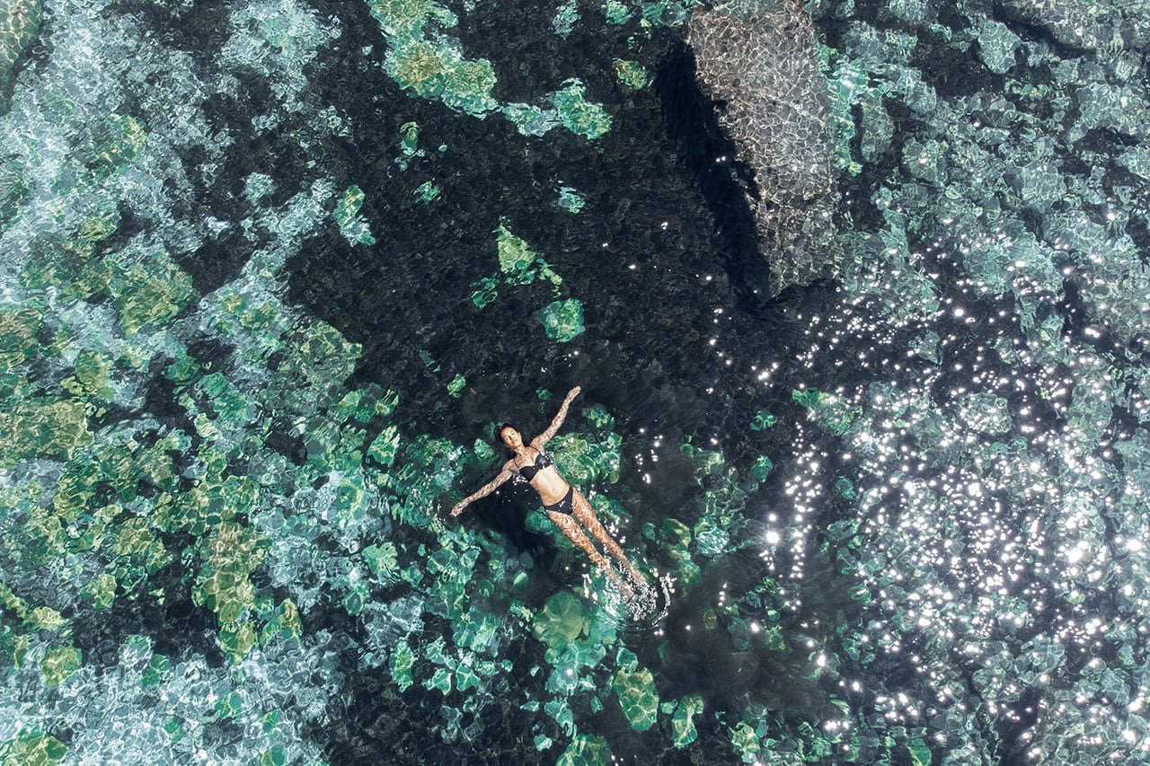 modelo flotando en agua vista dron para sesion fotografica resort hotel